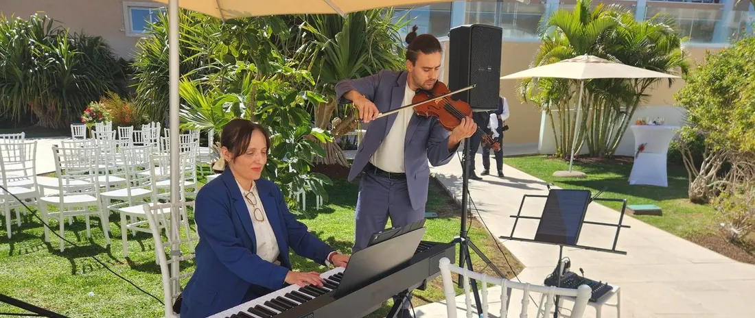 Dúo de violín y piano de SolFaMi actuando en un jardín